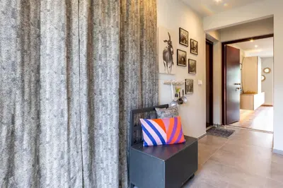 a hallway with a curtain and a pillow on a table at Mali Apartments Balcony in Tirolo