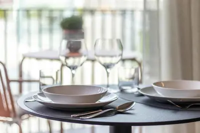 a table with plates and wine glasses on a balcony at Mali Apartments Balcony in Tirolo