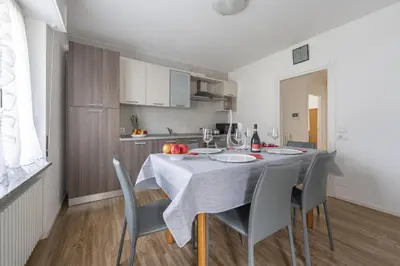 a kitchen with a table and chairs in a room at Appartamenti Primiero in Fiera di Primiero