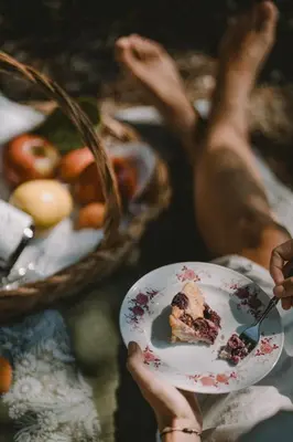 a person holding a plate with a piece of cake at Schnitzbichlhof in Lana