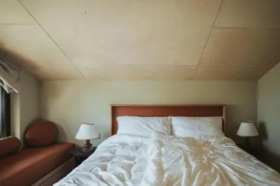 a bedroom with a white bed with two lamps at Schnitzbichlhof in Lana