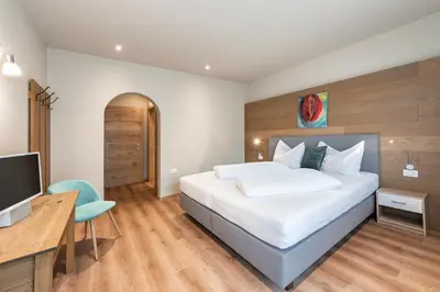 a bedroom with a bed and a desk and a television at Ursulas Idyll in Saltusio