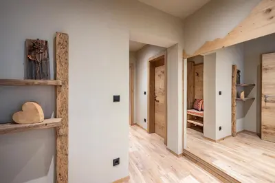 a hallway with white walls and wooden floors at Ursulas Idyll in Saltusio