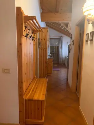 a wooden bench in a room with a hallway at Pragma Apartments - Appartamento Genziana in Predazzo