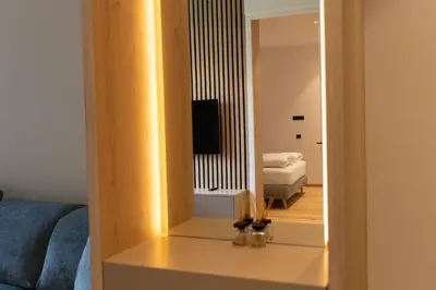 a living room with a mirror and a couch at Luxury Apartment Villa Ortler in Merano