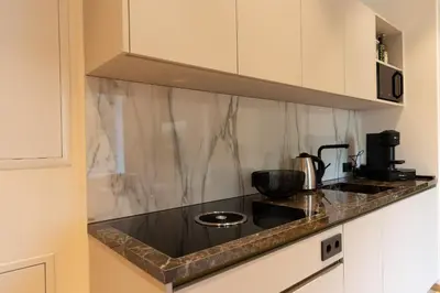 a kitchen with a black counter top with a coffee maker at Luxury Apartment Villa Ortler in Merano