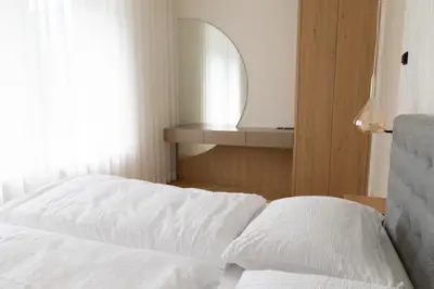 a bed with white sheets in a room with a window at Luxury Apartment Villa Ortler in Merano