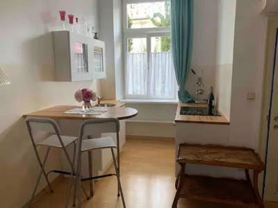 a kitchen with a table and chairs and a window at Helles Apartment in historischer Villa in Merano