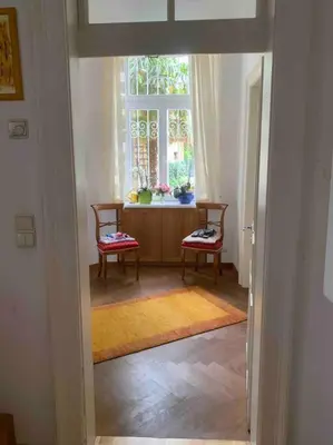 a hallway with two chairs and a window at Helles Apartment in historischer Villa in Merano