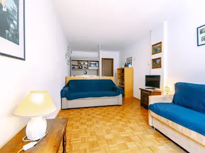 a living room with a blue bed and a couch at Apartment Solaria-2 by Interhome in Campestrin