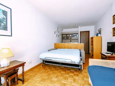 a bedroom with a bed and a couch at Apartment Solaria-2 by Interhome in Campestrin