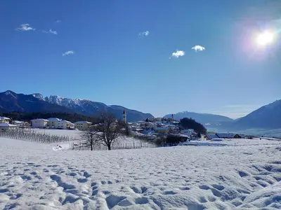 a snow covered field with a town in the background at APPARTAMENTO TOMA MIHAELA in Tres