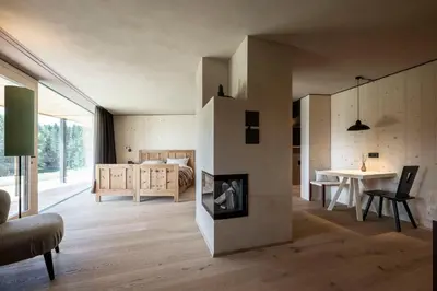 a living room with a fireplace and a bedroom at Rappersbühl in Collalbo