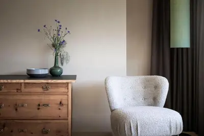 a chair sitting next to a dresser with a vase of flowers at Rappersbühl in Collalbo