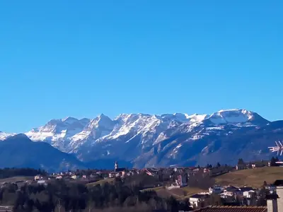 a city with snow covered mountains in the background at APPARTAMENTO ROEN in Cavareno