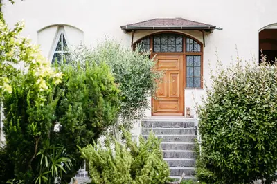 a house with a wooden door and stairs at Gästehaus Salvatorianerinnen in Merano