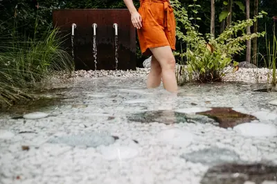 a woman in an orange dress standing in a puddle at Gästehaus Salvatorianerinnen in Merano