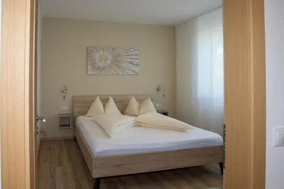 a bedroom with a bed with white sheets and pillows at Appartement 7 in Caldaro