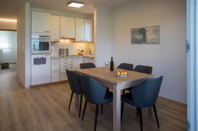 a kitchen and dining room with a wooden table and chairs at Appartement 7 in Caldaro