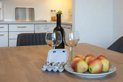 a table with a plate of apples and a bottle of wine at Appartement 7 in Caldaro