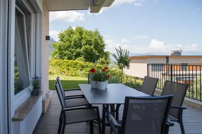 a patio with a table and chairs on a balcony at Appartement 7 in Caldaro