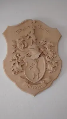 a wooden plate with a crest on a wall at Garni Rives in Ortisei