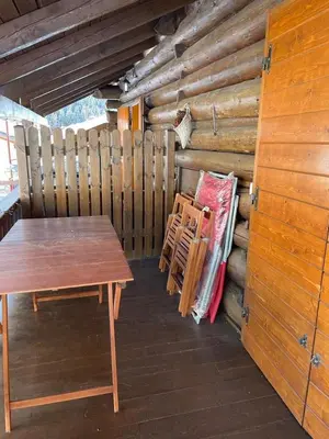 a wooden table and chairs in a log cabin at El Fienil in Mazzin