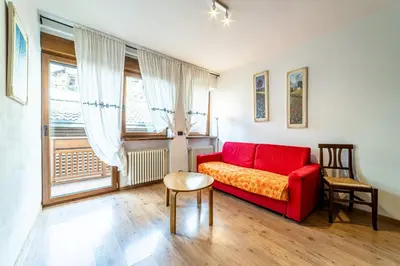 a kitchen with wooden cabinets and a staircase at Appartamento Dolomiti Alleghe in Alleghe