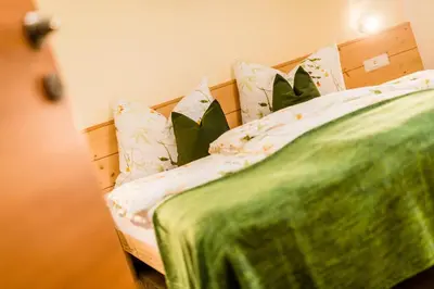 a bed with a green blanket and pillows at Mandlerhof in Verano