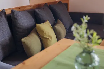 a couch with pillows on it with a table at Mandlerhof in Verano