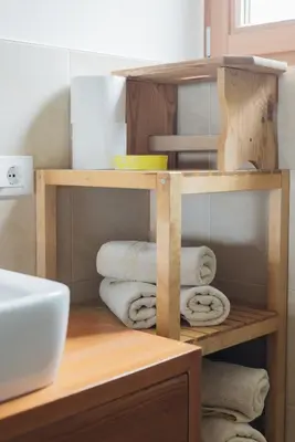 a bathroom with a wooden shelf with towels at Mandlerhof in Verano