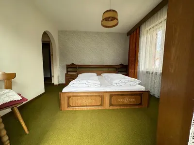 a bedroom with a bed with white sheets and a window at APARTMENTS Gasser in Monguelfo
