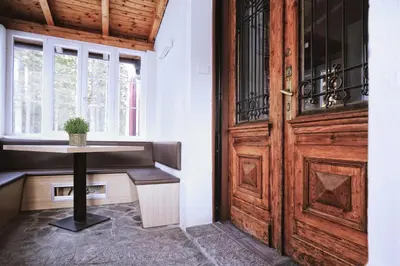 a room with a door and a table next to a window at Hotel Croda Rossa in Carbonin