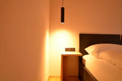 a bedroom with a bed and a nightstand with a light at Kastelart - Karbon in Castelrotto