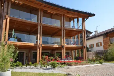 a large wooden building with a lot of windows at Kastelart - Karbon in Castelrotto
