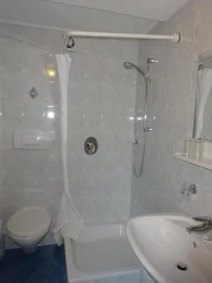 a bathroom with a shower and a toilet and a sink at Pension Hasslhof in Caldaro