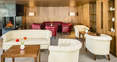 a restaurant with white furniture and red chairs at Pension Hasslhof in Caldaro