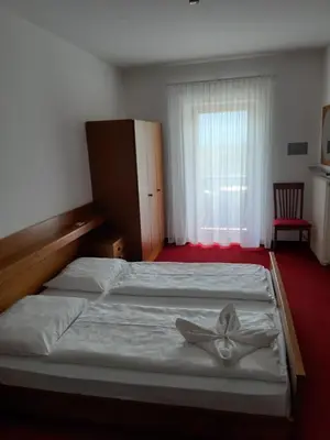a bedroom with a bed with a flower on it at Pension Hasslhof in Caldaro