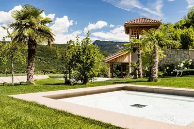 a pool in the middle of a yard with a house at Pension Hasslhof in Caldaro