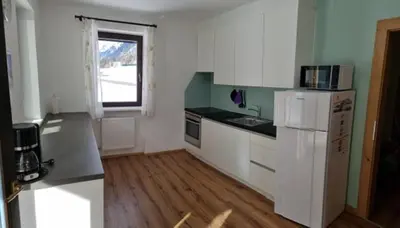 a kitchen with white appliances and a window at Ottohof - Morgenrot in Brennero