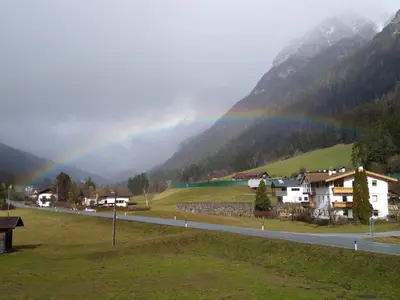 a rainbow over a village with a road and houses at Ottohof - Morgenrot in Brennero