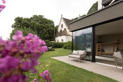 a house with a garden with a chair and some flowers at Stadler Hof in Lana