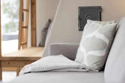 a couch with a pillow on it with a chair at Stadler Hof in Lana