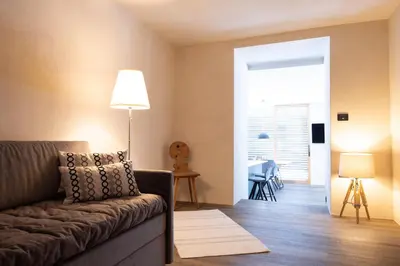 a living room with a couch and a dining room at Stadler Hof in Lana