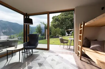 a bedroom with a bunk bed and a table and chairs at Stadler Hof in Lana
