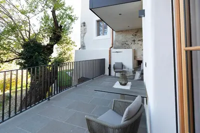a patio with chairs and a table on a balcony at Stadler Hof in Lana