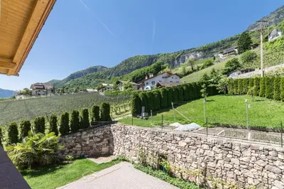 a view of a stone wall and a hill with trees at Goldenhof Penon in Penone