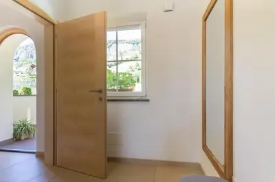 a hallway with a wooden door and a window at Goldenhof Penon in Penone