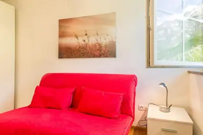 a red couch with two red pillows in a room at Goldenhof Penon in Penone