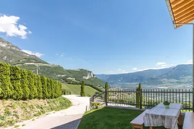 a garden with a table and a fence and mountains at Goldenhof Penon in Penone